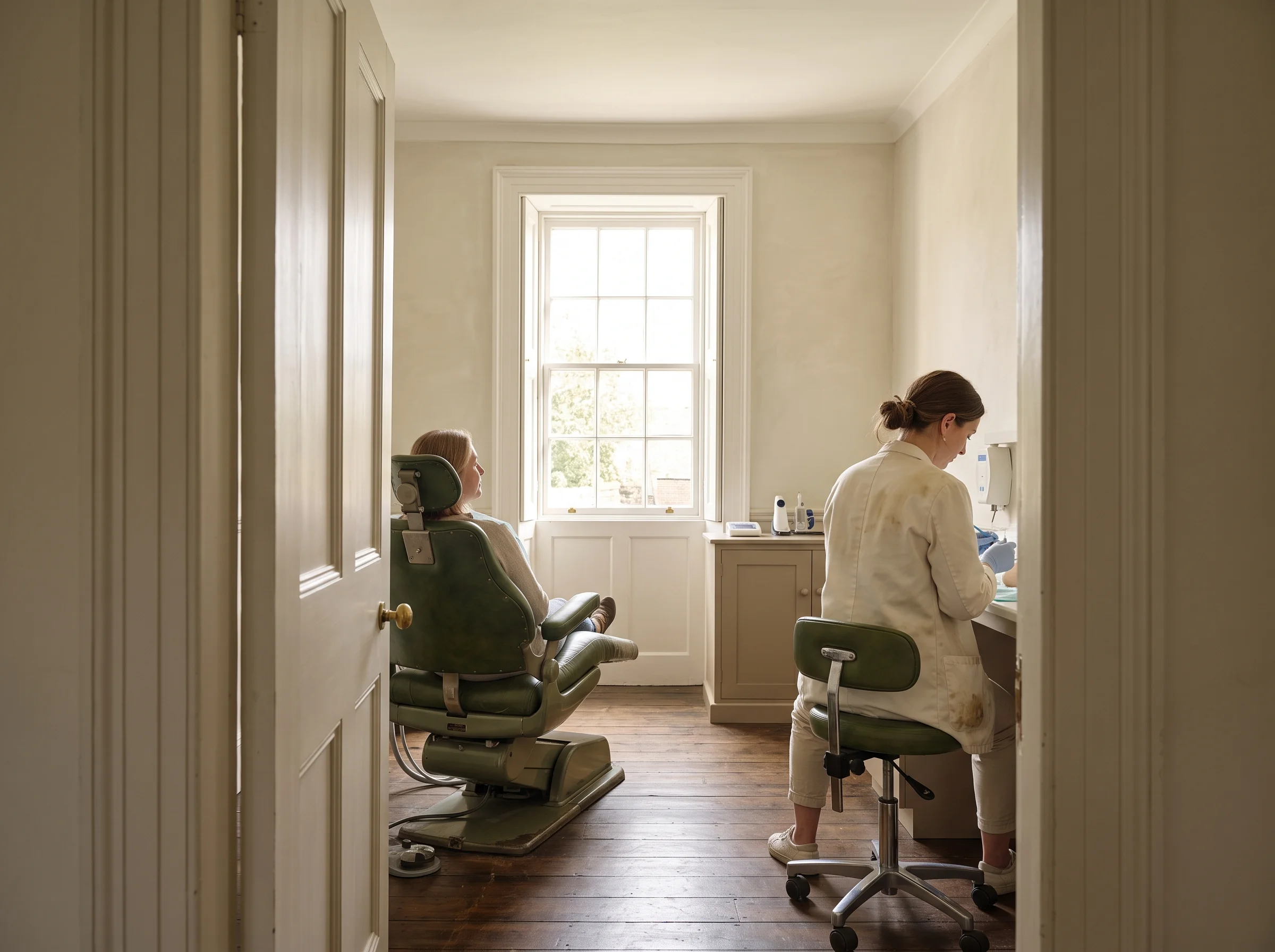 Anna's surgery seen from the doorway, with the chair in the middle of the room and the sash window open beyond it